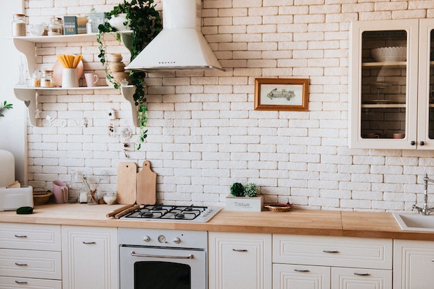 helle, gemütliche Küche mit weißen Backsteinen an der Wand.