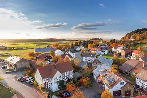 Ein Dorf von oben fotografiert und einem Feld davor.